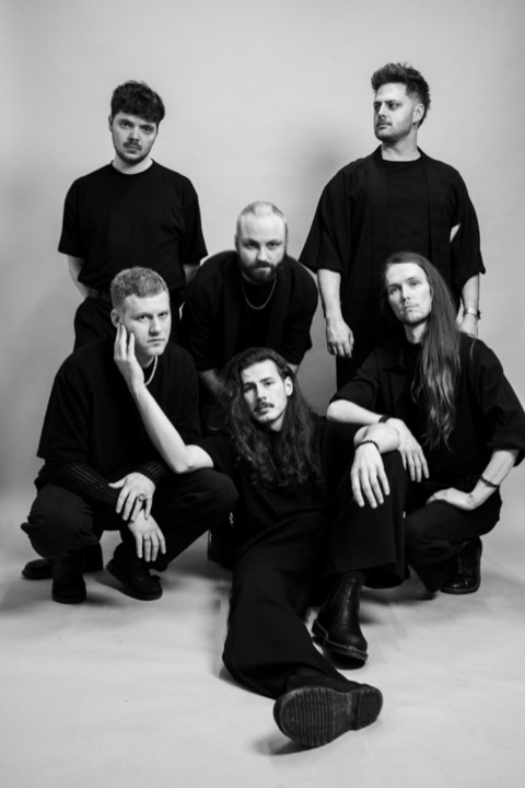 Seated group portrait of the six members.