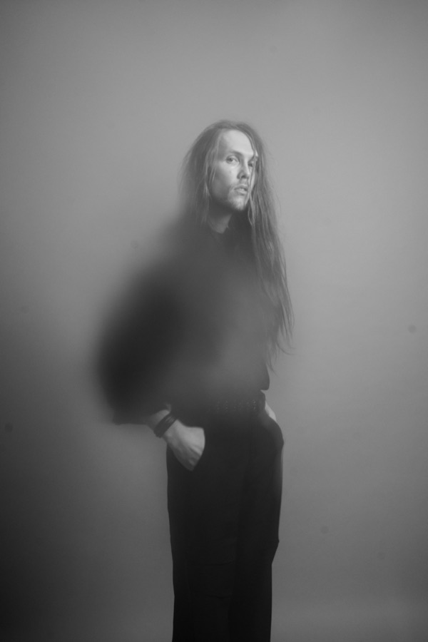 Hannes of One Lunar Day, photographed in black against a pale studio wall.