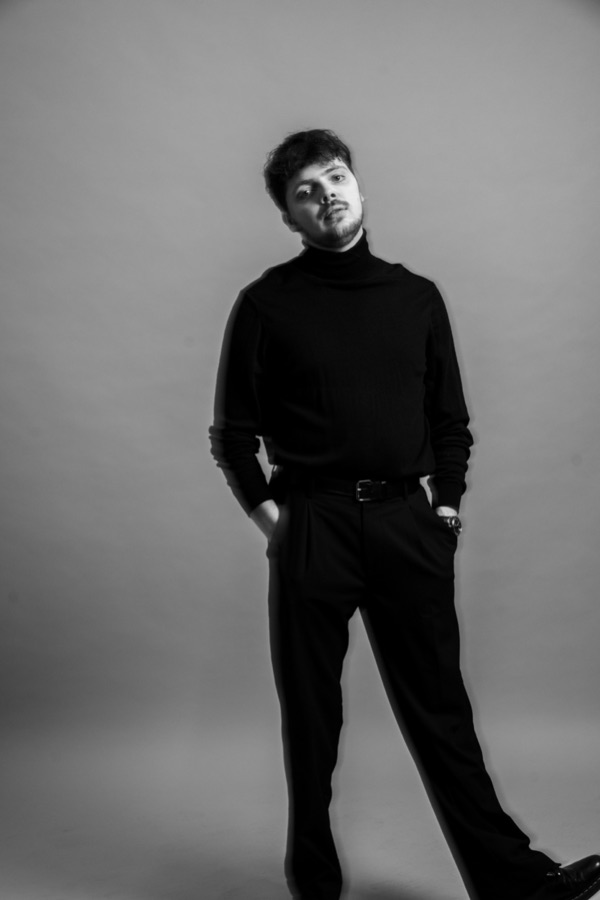Michael of One Lunar Day, photographed in black against a pale studio wall.