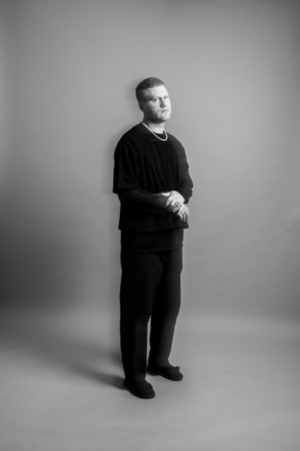 Rune of One Lunar Day, photographed in black against a pale studio wall.