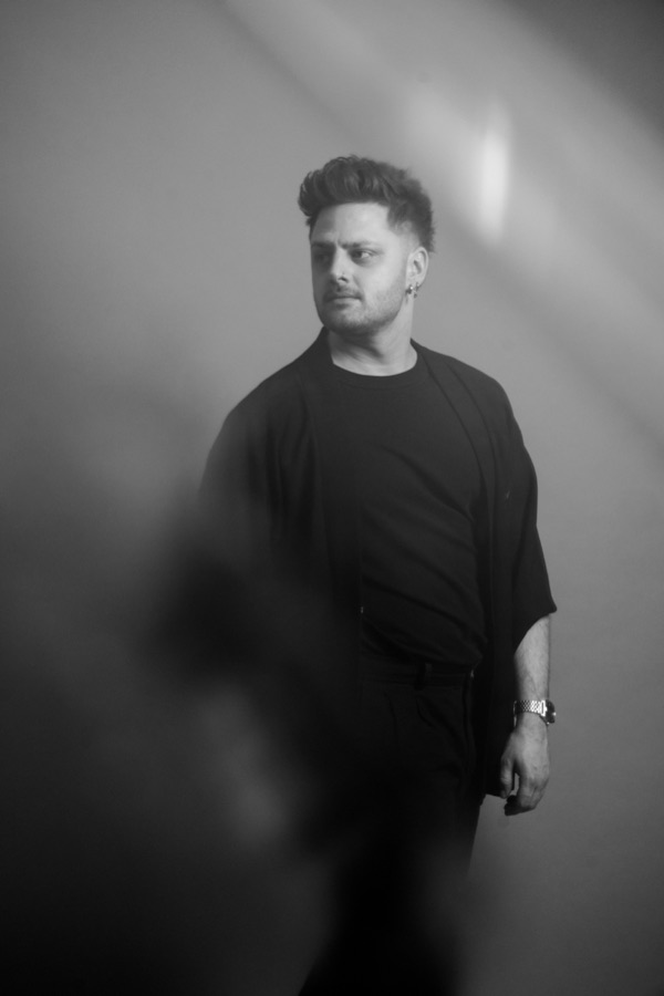 Timo of One Lunar Day, photographed in black against a pale studio wall.